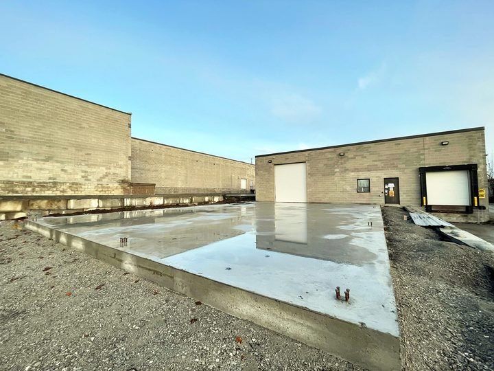 Concrete floor work inside a large building shell